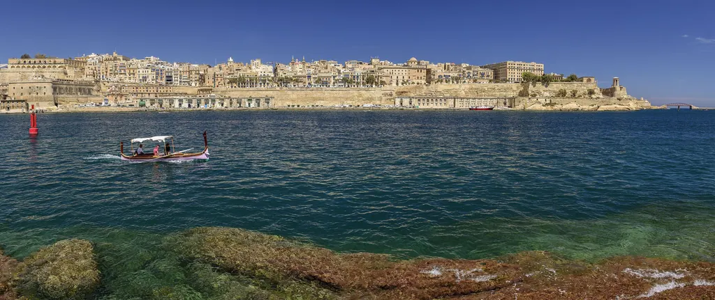 Valletta skyline seen from Birgu with a traditional luzzu
